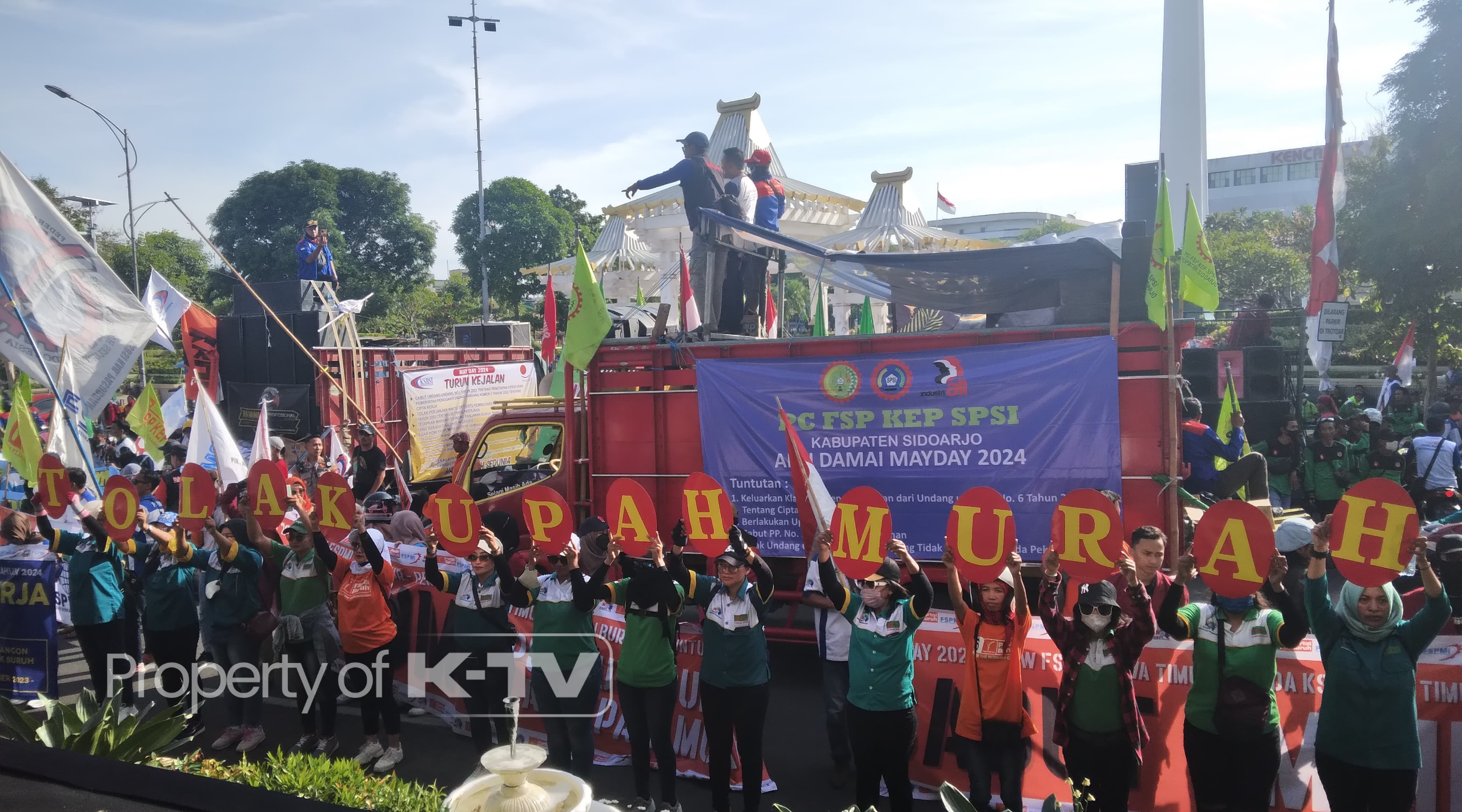 MENUNTUT: Para buruh berkumpul di depan Kantor Gubernur Jawa Timur melayangkan sejumlah tuntutan. (K-TV/Rifka Amelia) 